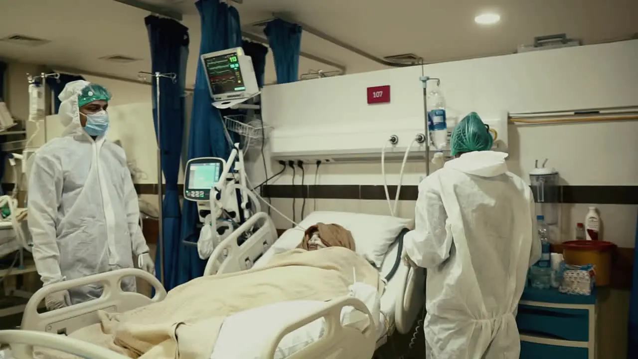 Doctors Tending To Covid-19 Patient Lying In A Hospital Bed