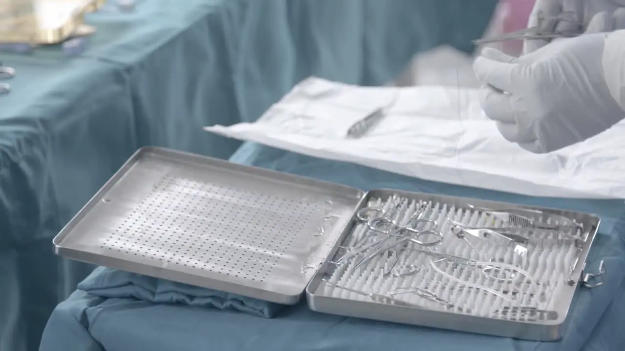 Nurse preparing stainless steel wire on tweezers on little table