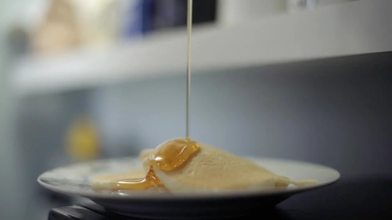 CBD THC infused cannabis oil syrup poured over pancakes in slow motion