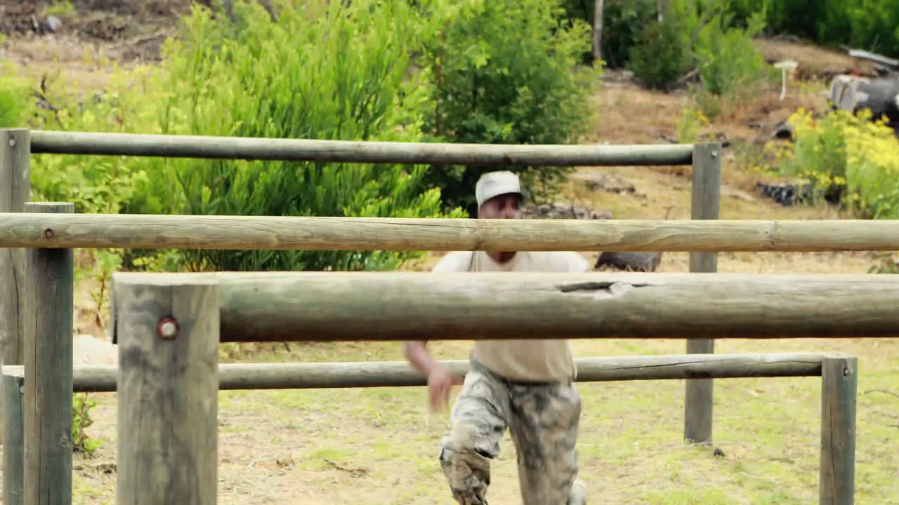 Fit man jumping over the hurdles during obstacle course