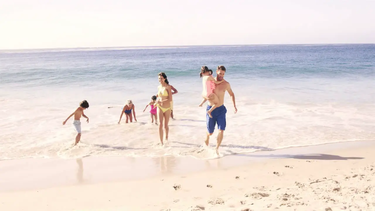 Cute family running out of the water on the beach