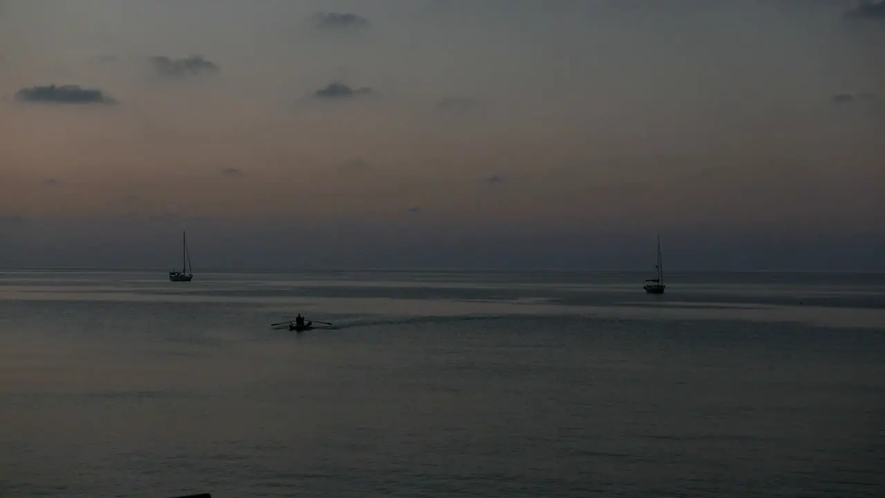 Small boats in silhouette at sunset