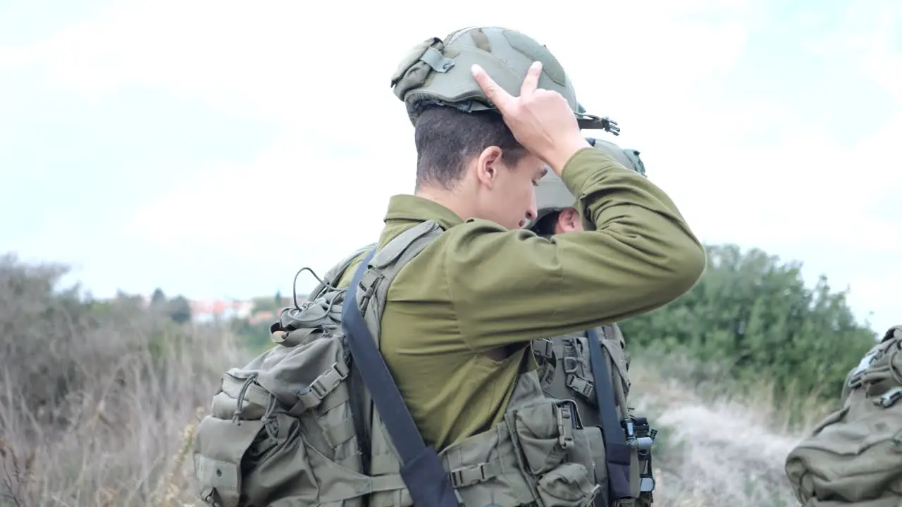 Israeli brigade soldier put on helmet medium shot profile view Golan heights