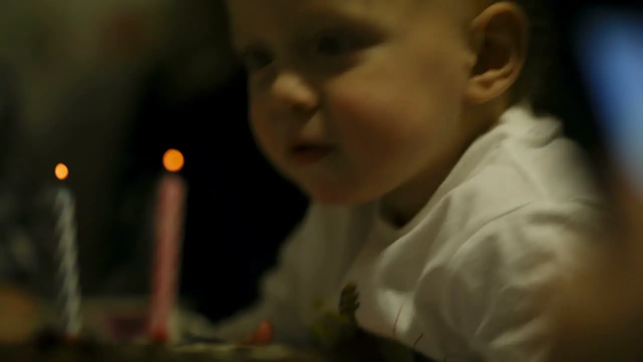 Little boy blowing out two candles on his birthday cake