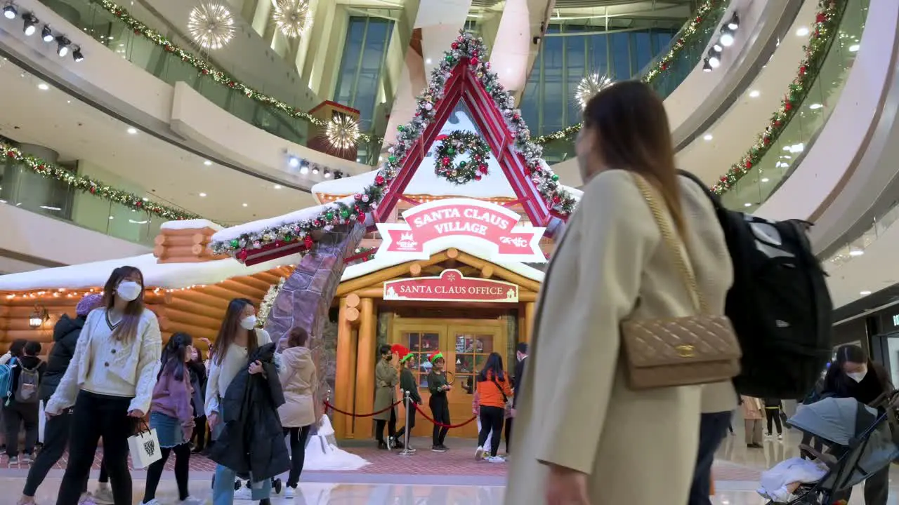 Chinese shoppers walk past a Christmas installation event at a shopping mall in Hong Kong