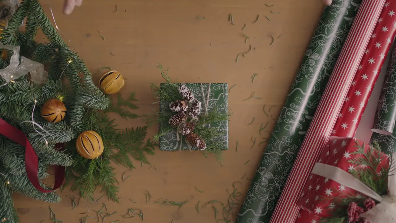 A top-down plan Fully visible the table with the decorations Christmas gift wrapped in craftool paper on a wooden table Bandaging tape and tied bow