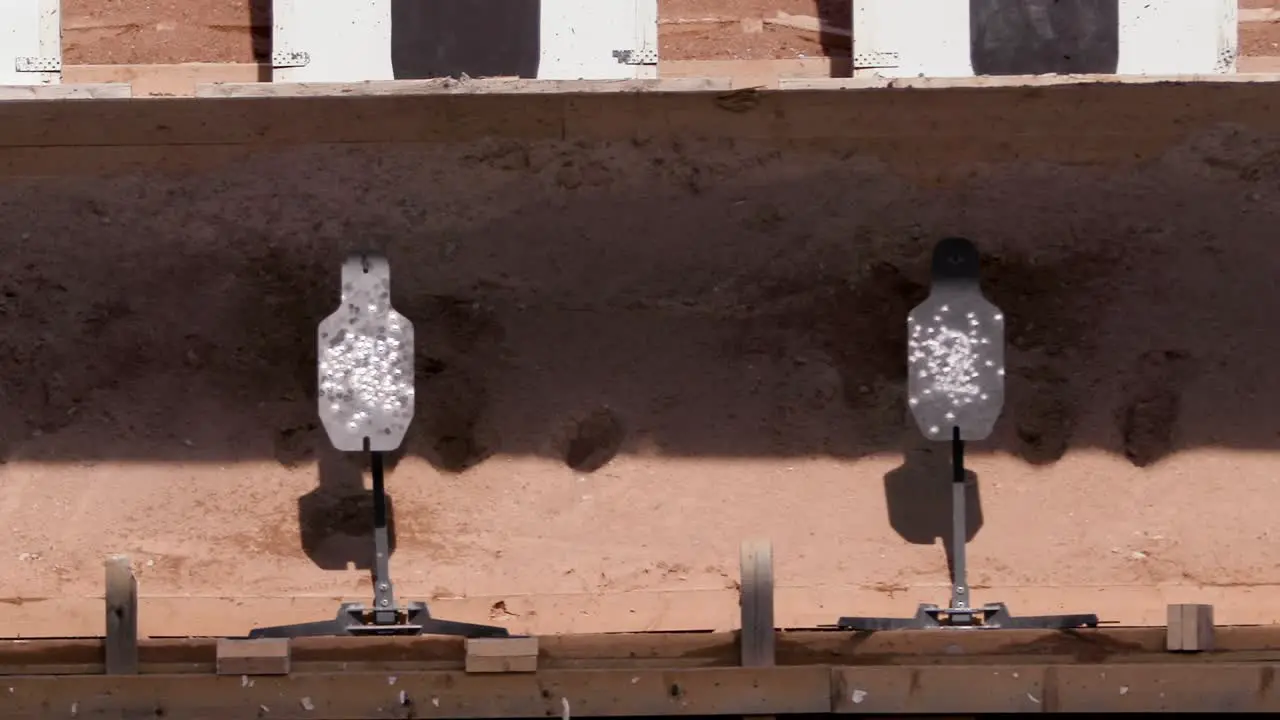 Bullets hit metal target in shooting range closeup slow motion