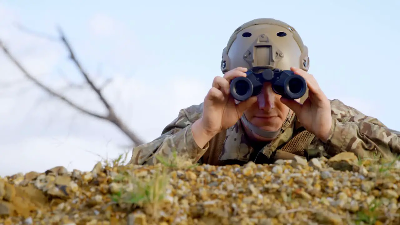 Front view of military soldier looking through binoculars during military training 4k