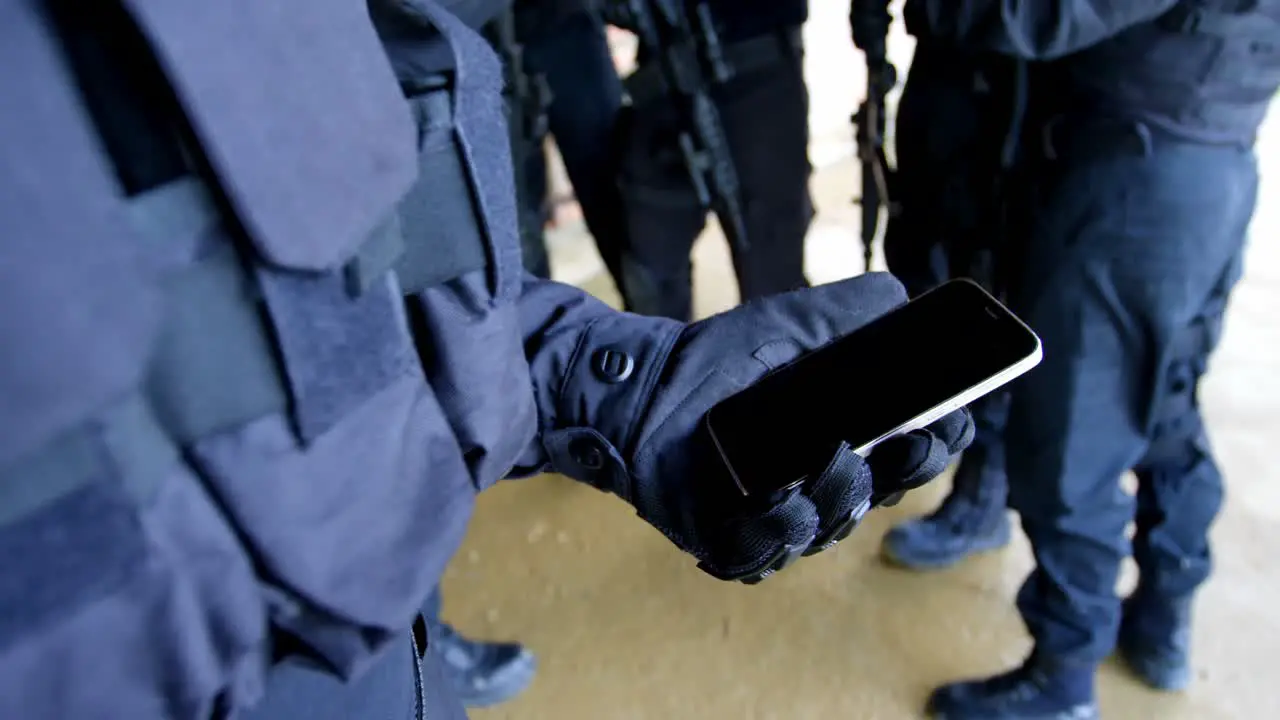 Close-up of military soldier holding mobile phone at military base 4k