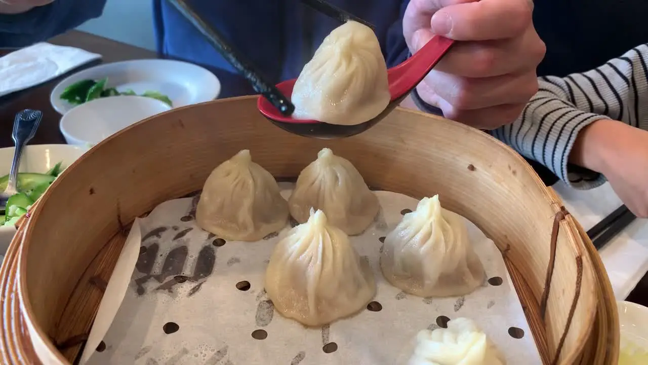 A video tutorial on how to eat traditional soup dumplings at a Chinese restaurant