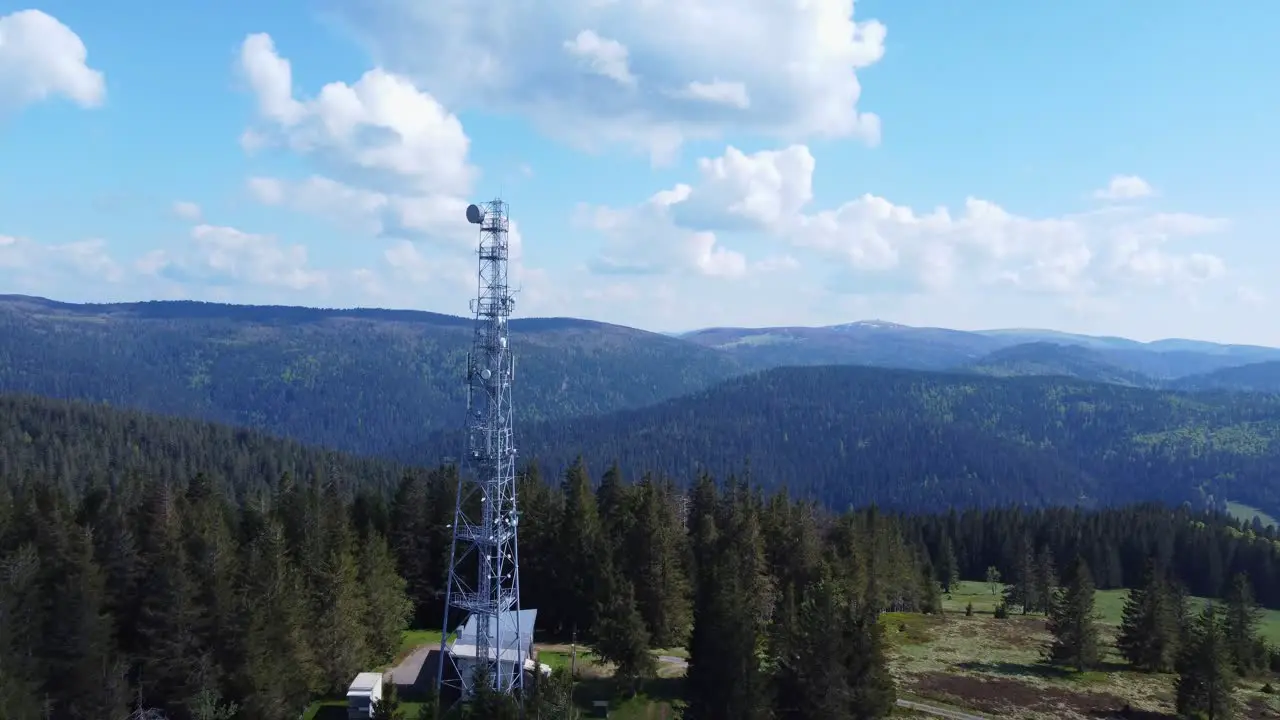 Aerial view of a 5G telecom antenna mast pylon among mountain forest in Sérichamp Vosges France 4K