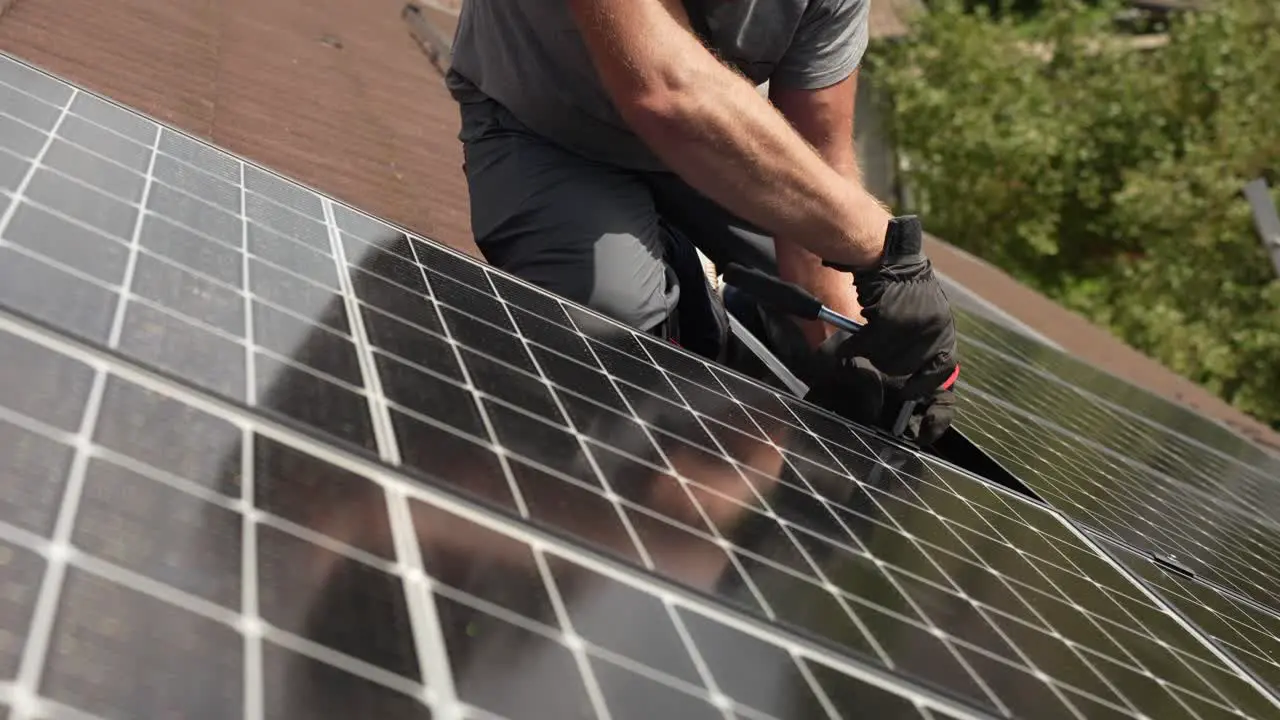 Technician attaching solar panel to roof of customers house sustainable energy