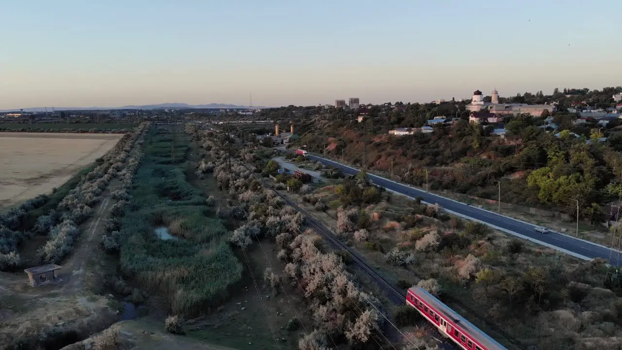 Red Local Train Traveling Along The Vehicles Driving In The Road