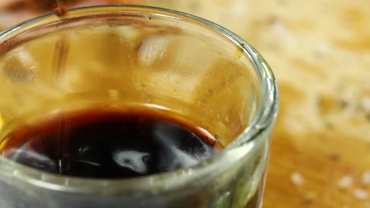 Macro shot of fried squid dipping into soy sauce