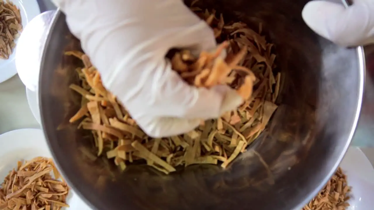 Hands putting corn chips in many bowls