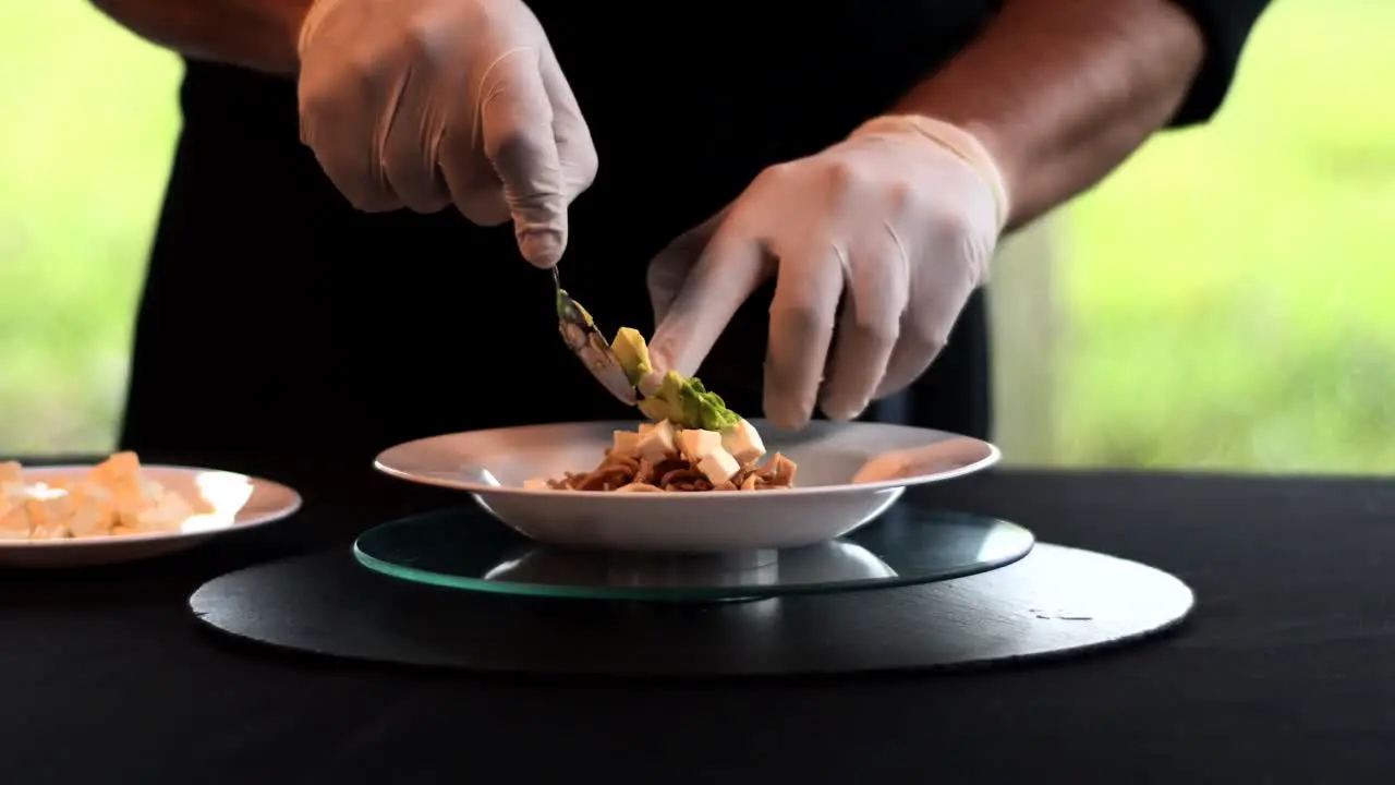 Hands with a spoon putting avocado and cream in a bowl