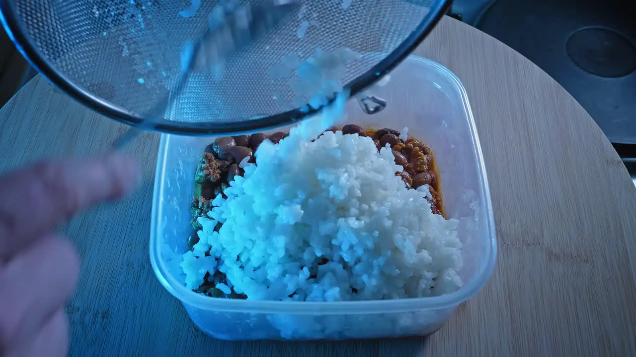 Adding Plain White Rice On Top Of Cooked Ground Turkey With Beans In Food Container