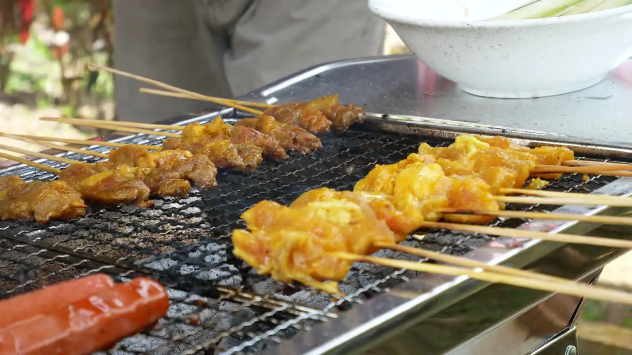 A man is grilling Satay