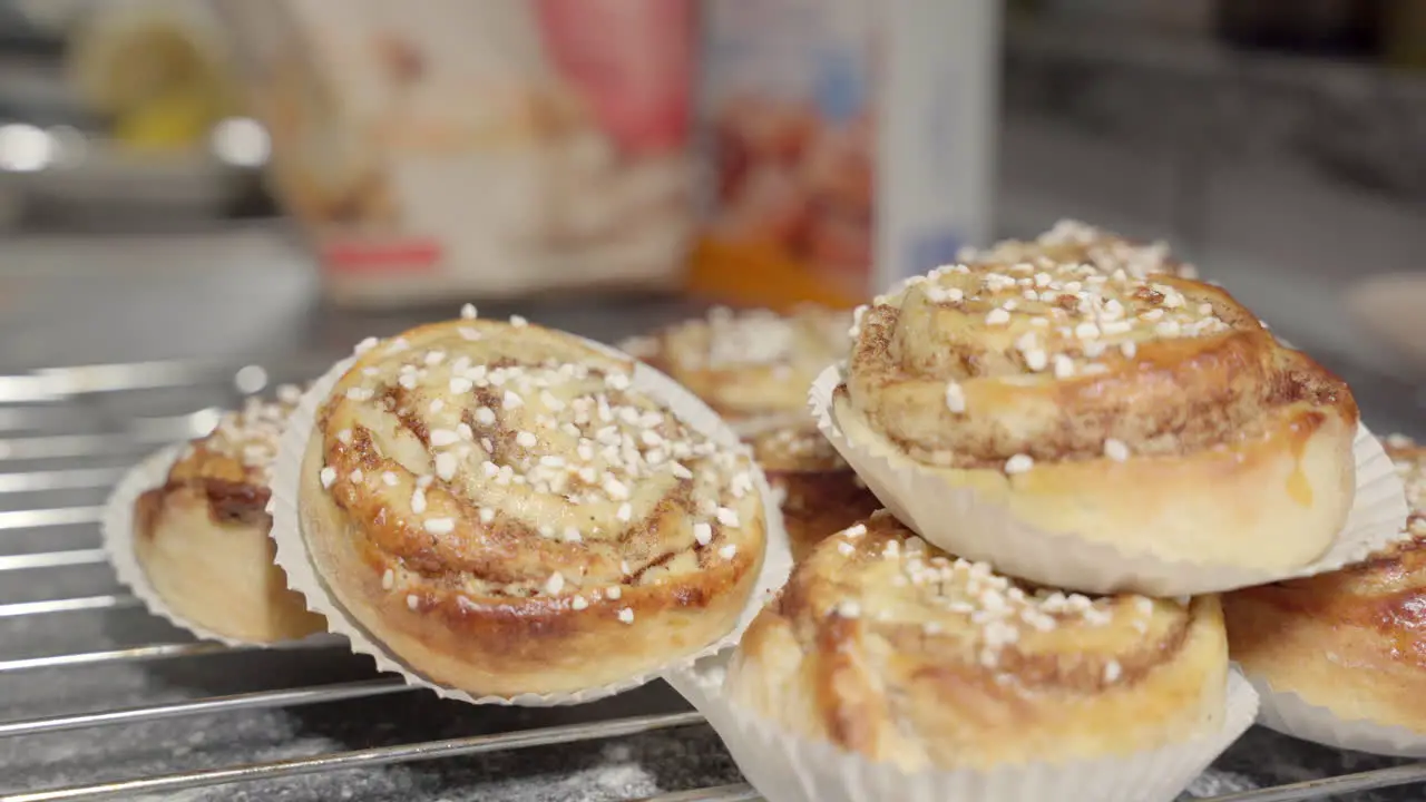 Male hand picking up a cinnamon bun in the background out of focus