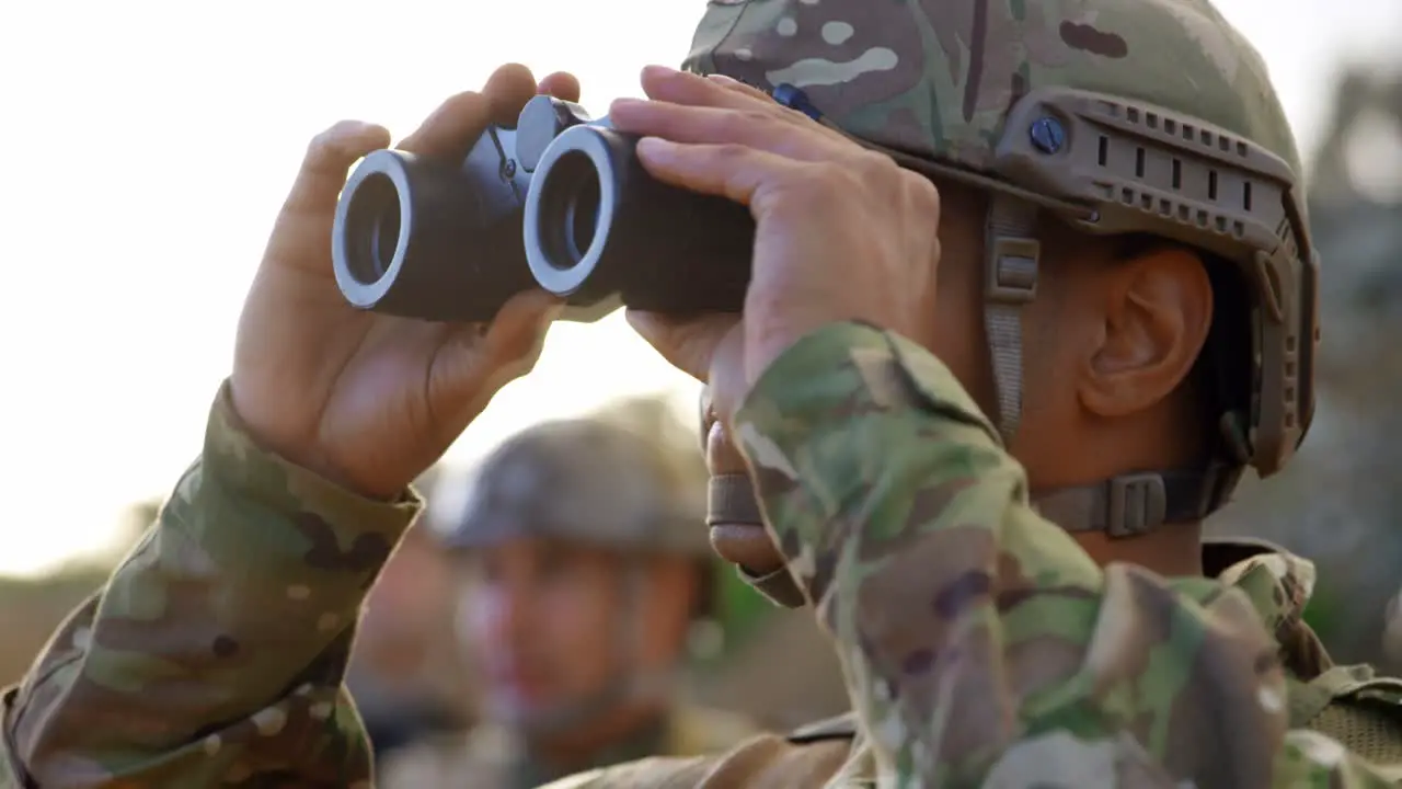 Side view of young caucasian military soldier observing on field during military training 4k