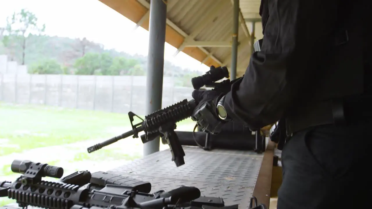 Side view of young black military soldier loading rifle during military training 4k