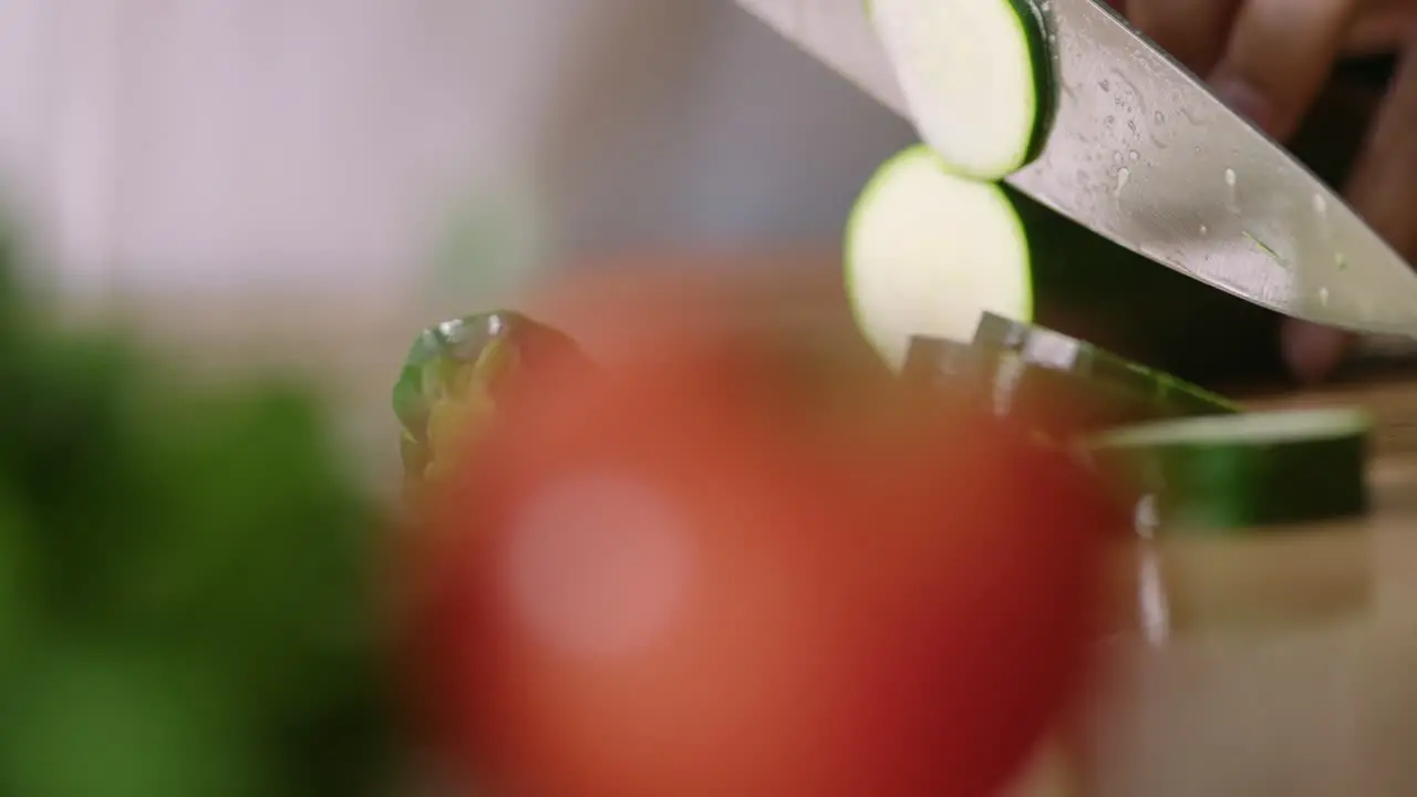 Chef in kiitchen cutting cucumber