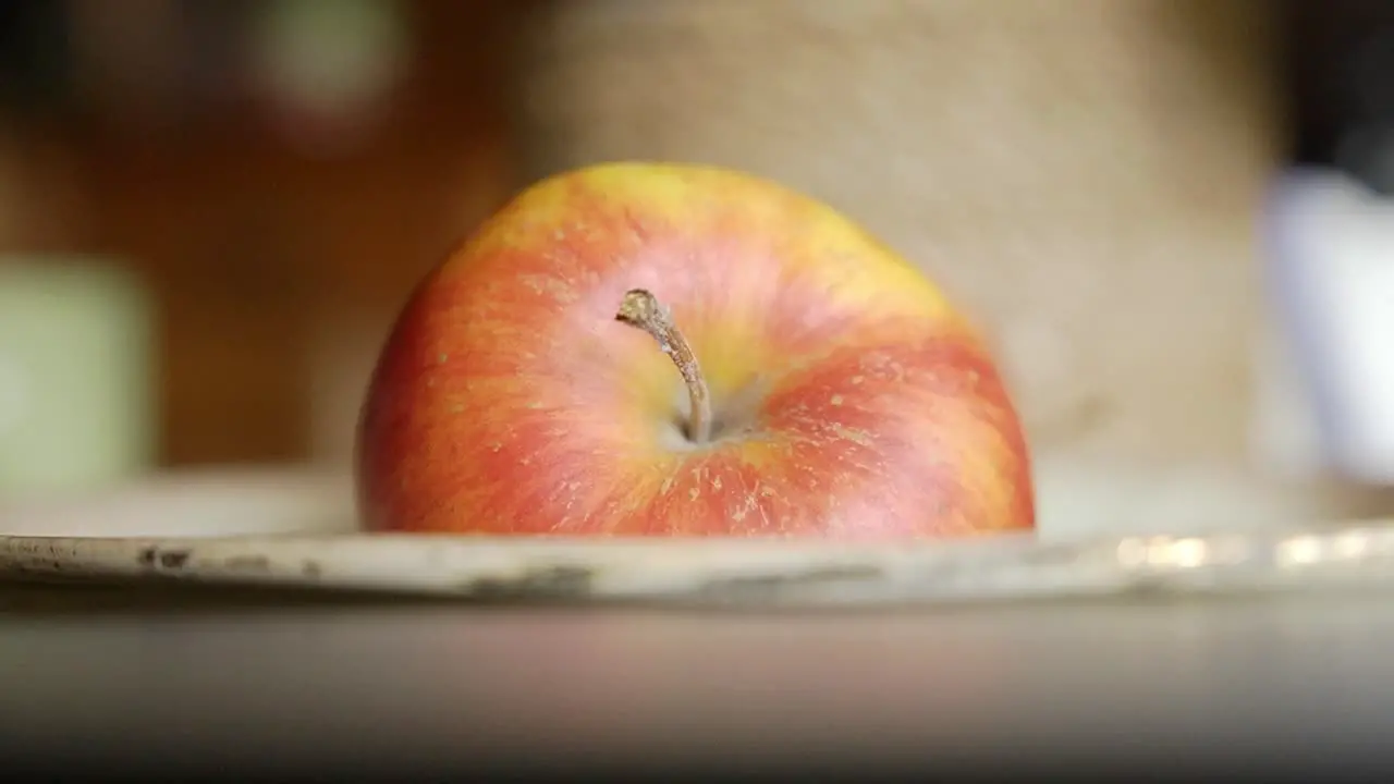 Close up view of red apple laying in a bown on the dining table