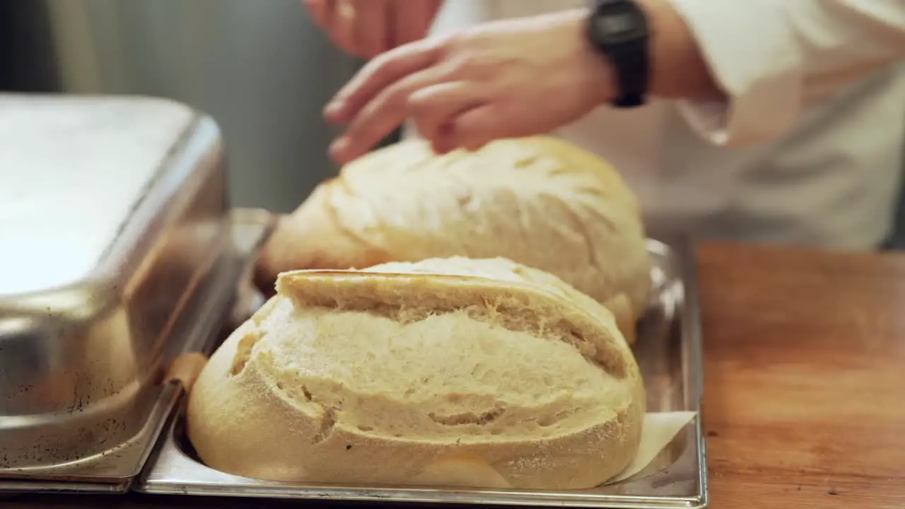 baker turns the bread and puts it in the oven