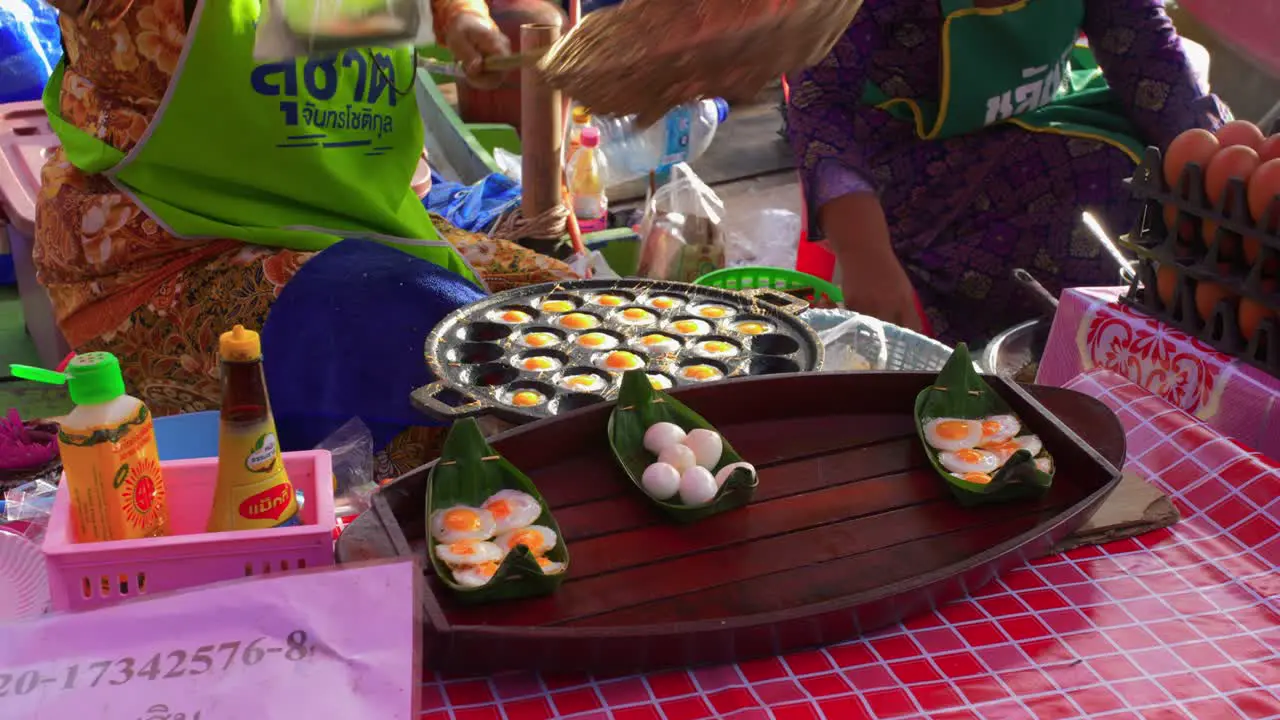 Static close up of woman selling little fried eggs in local asian outdoor market