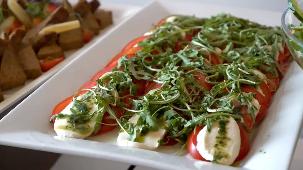 Platter with tomatoes mozzarella arugula and pesto