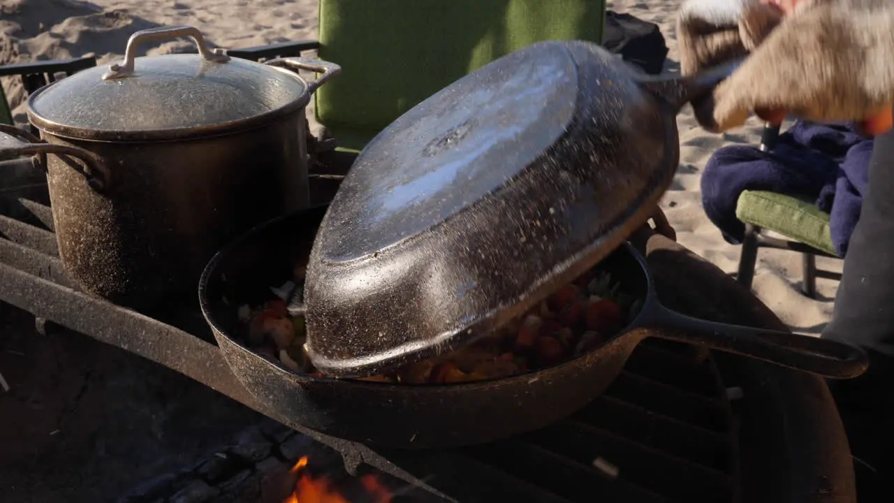 Delicious food being prepared in pots on the campfire