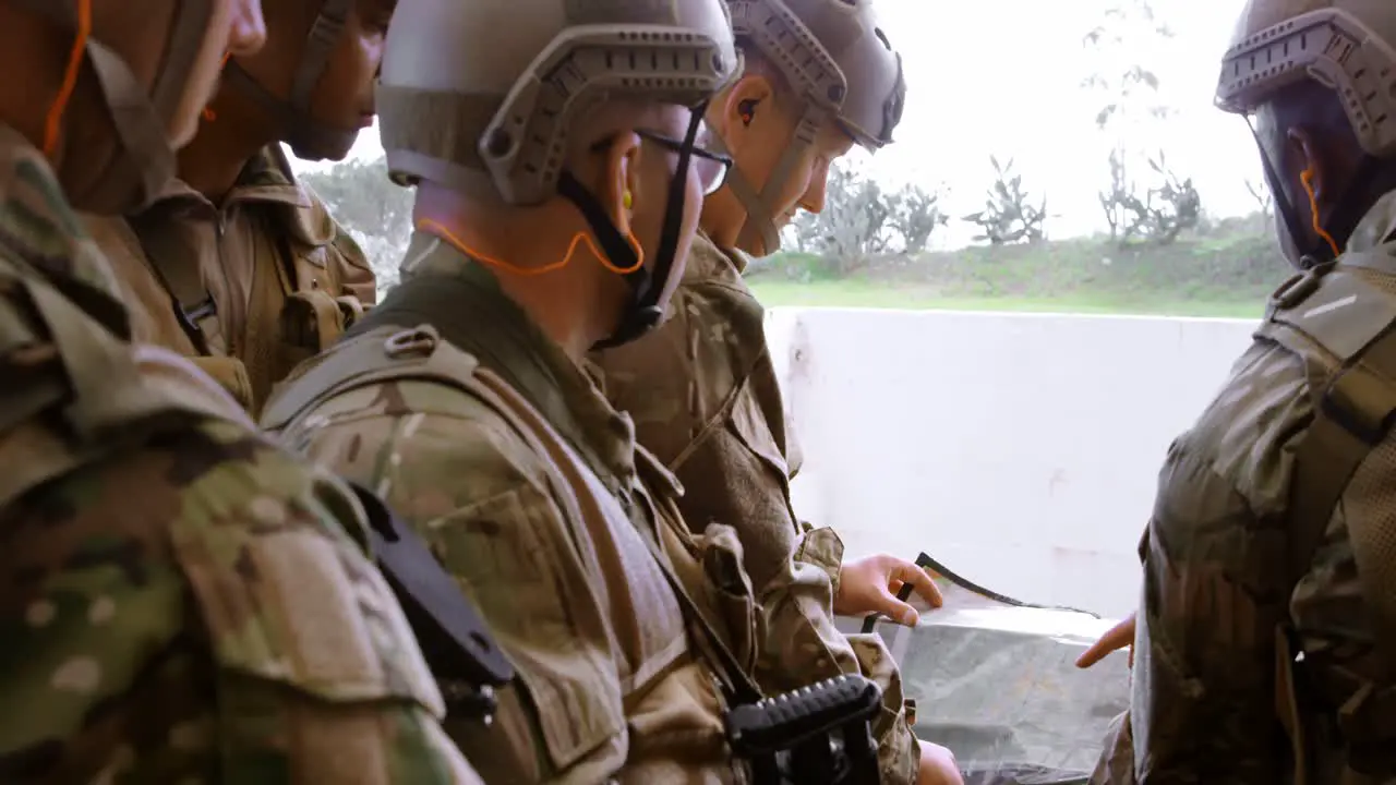 Side view of mixed-race military soldiers with rifle planning during military training 4k