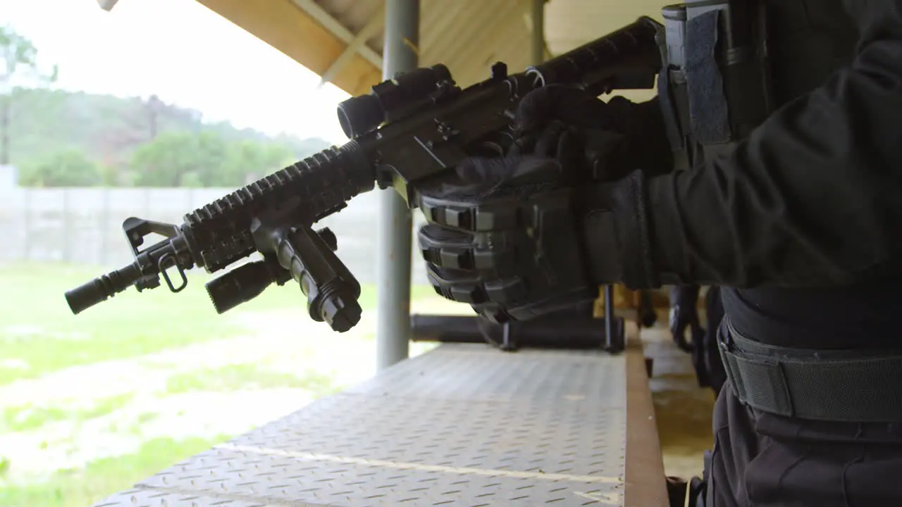 Mid section of young military soldier loading rifle magazine during military training 4k