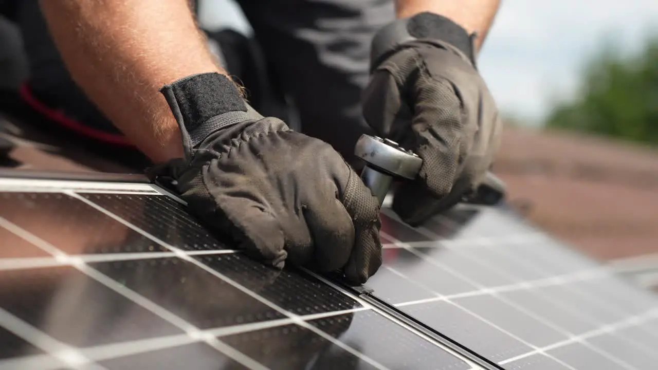 Technician bolting solar panels together on roof for sustainable future