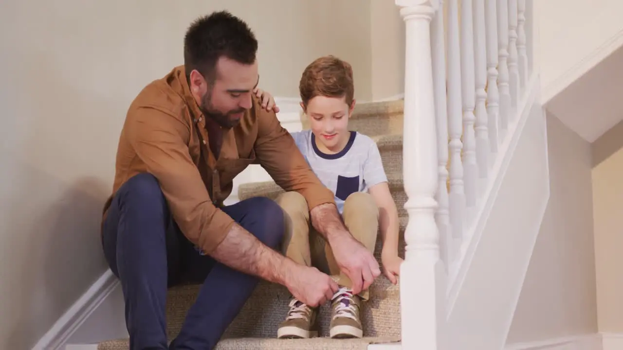 Caucasian man and his son sitting on the stairs