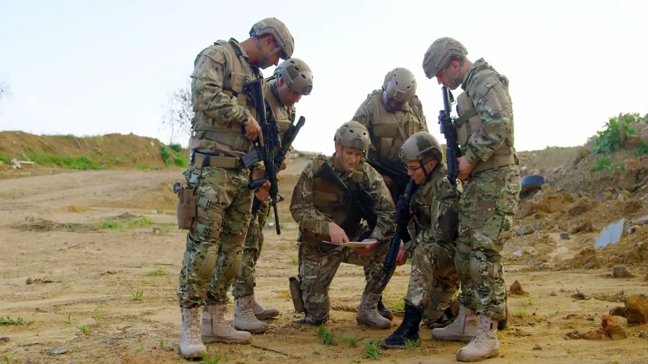 Front view of mixed-race military soldiers planing on field during military training 4k