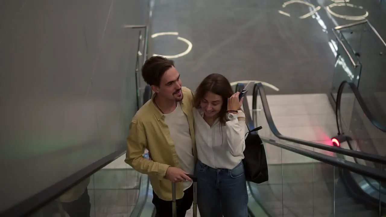 Loving Couple On The Escalator At The Airport