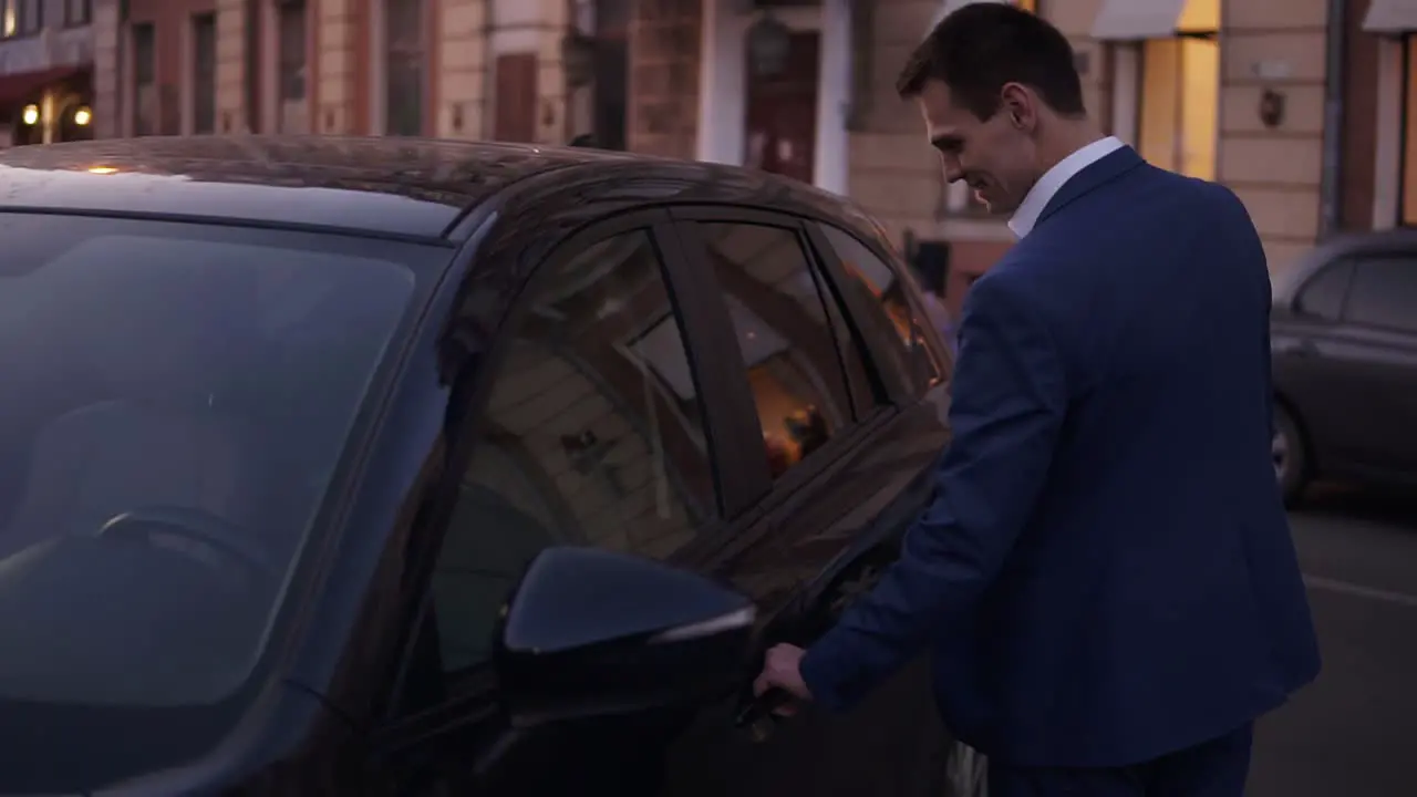 Slow Motion Young Man Walk Sitting In His New Black Car On Street