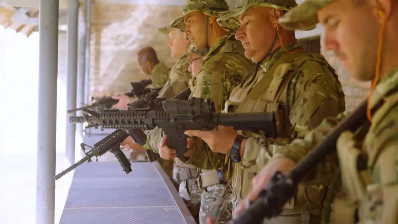 Side view of mixed-race military soldiers loading weapon during military training 4k