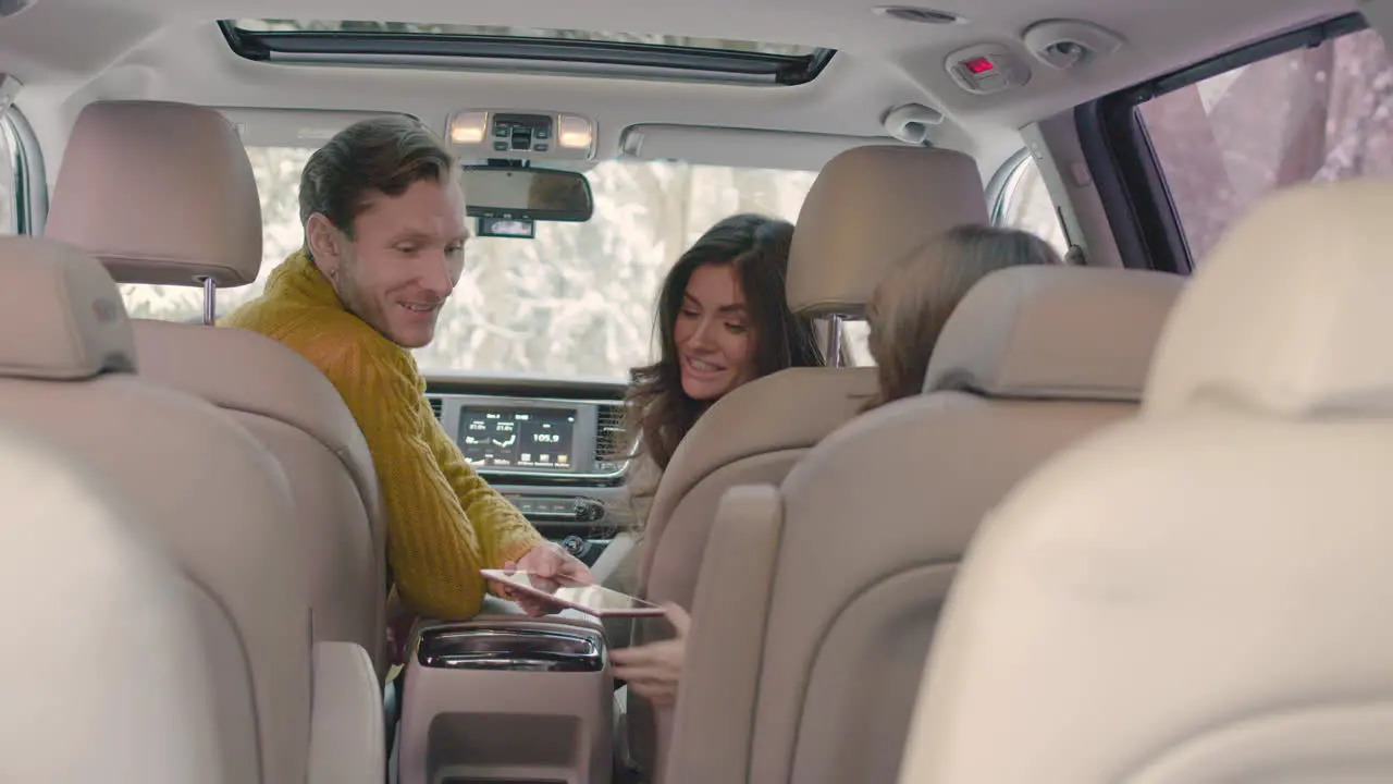 Rear View Of A Husband And Wife Sitting In The Front Seats Of A Car