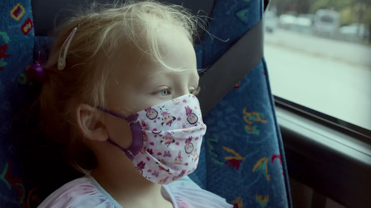 Small girl traveller yawning in a mask