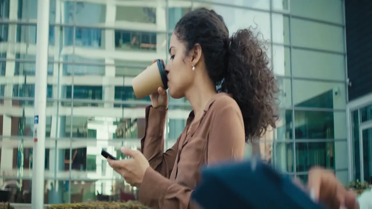 Video of businesswomen walking with digital tablet and coffee outdoors