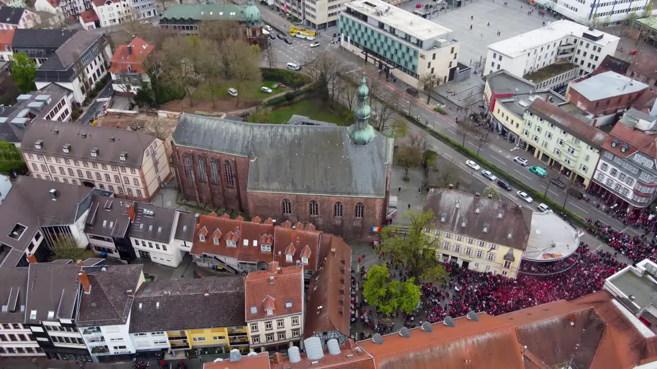 Aerial rising up tilting down FCK Football audience fans crowd celebrating win at the bars of old city in Kaiserslautern Germany