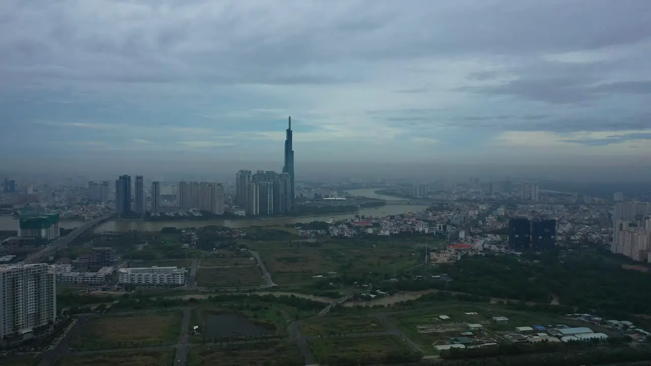 Long Fly in towards river and modern city development with high rise towers in early morning