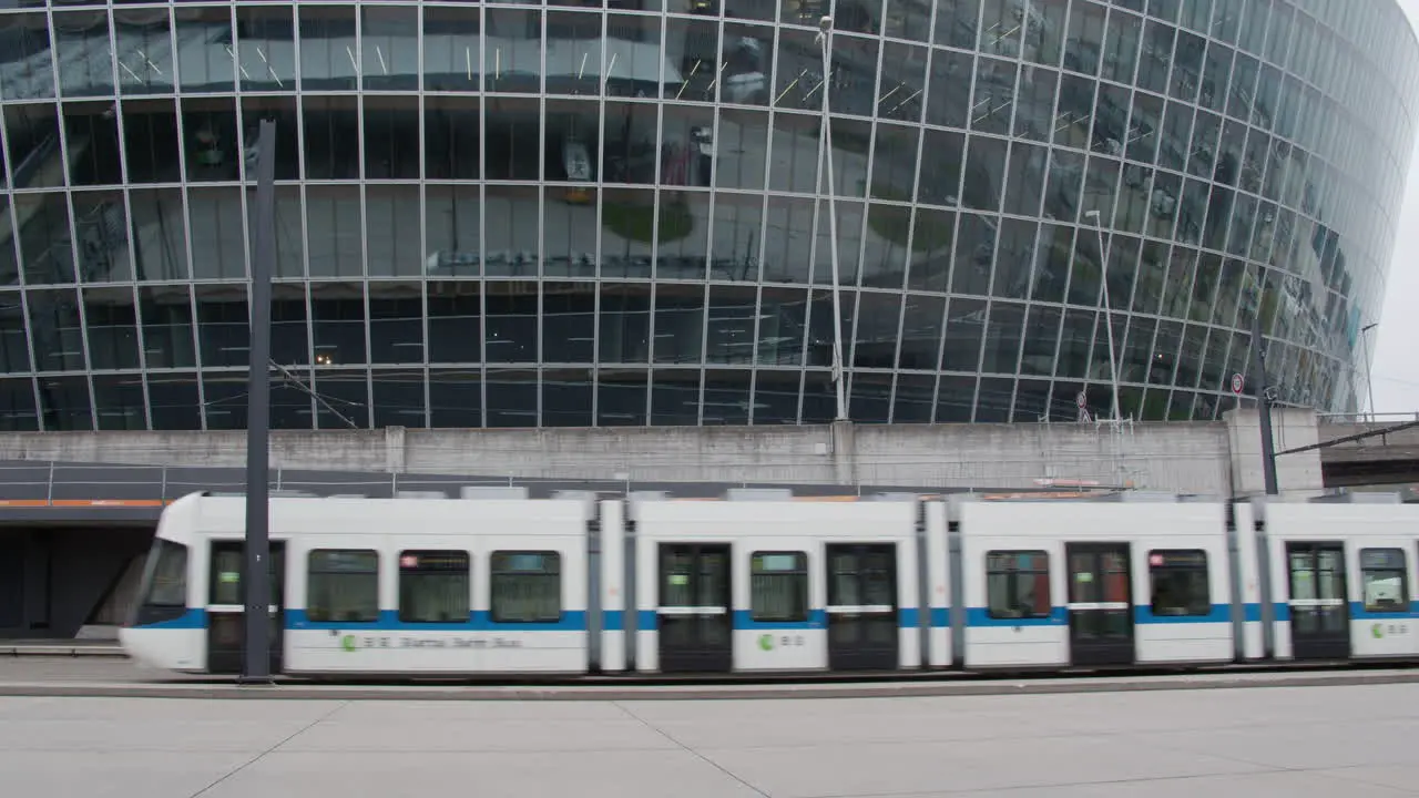 Tram passes by against an office building