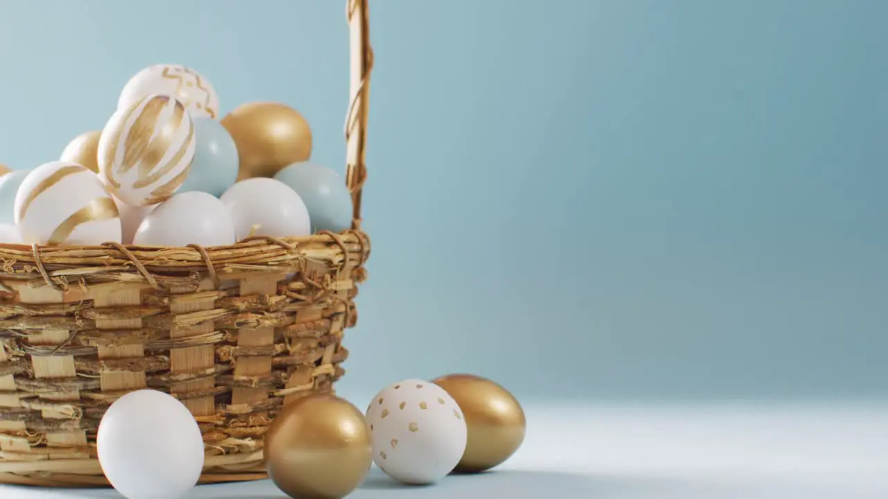 Basket with colorful easter eggs on blue background with copy space