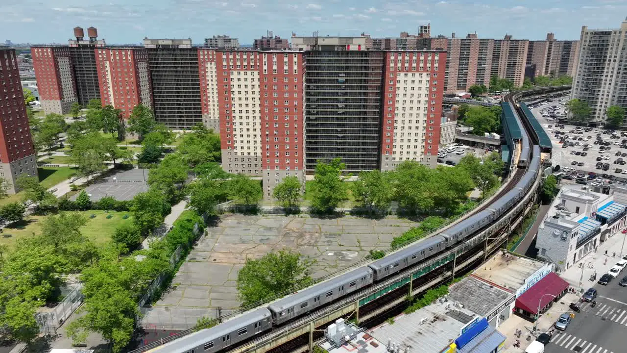 New York City passenger train passing tall apartment buildings in Coney Island NYC