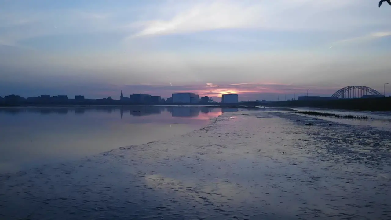 Awe Inspiring Sunrise over an Industrial City Area with Iron Arch Bridge Over River Bank as a Bird Flies By Slow Motion Slomo  Drone Aerial