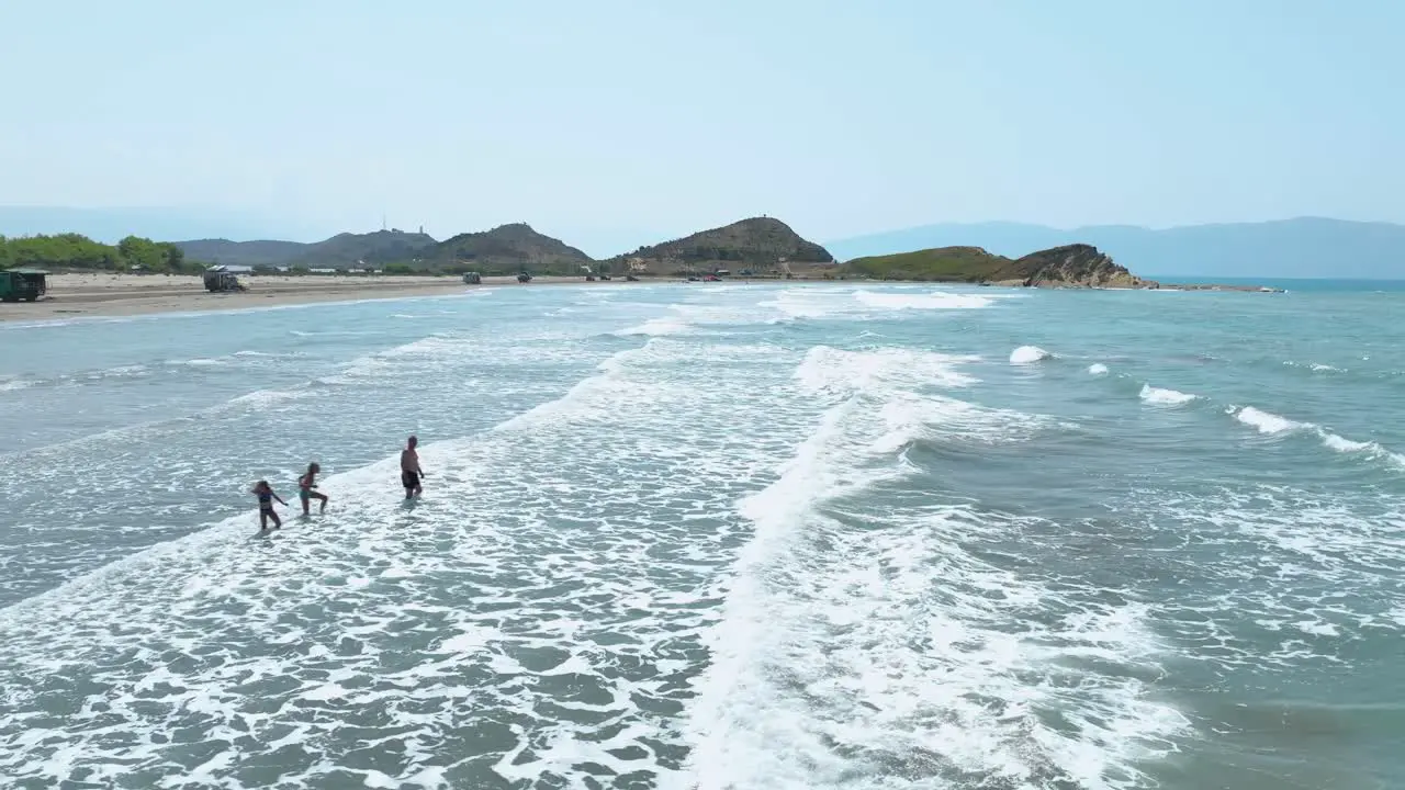 Family playing with the waves and going for a swim in the sea