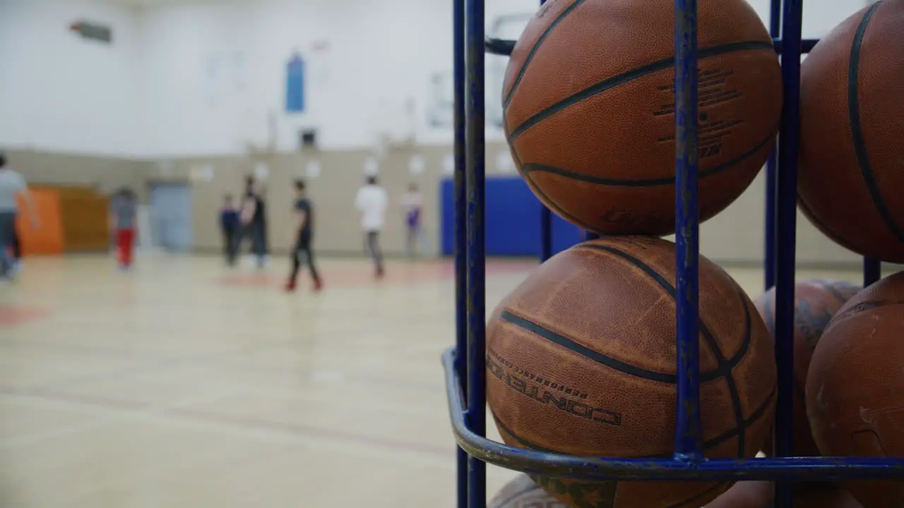 Several basketballs in a cage during gym class high school